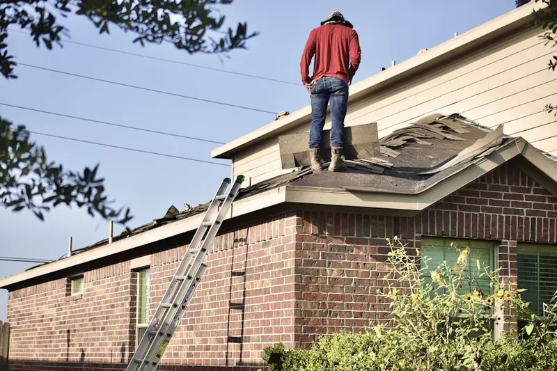 Professional roofer working on a residential roof in Whidden Corner
